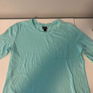 Teal 3/4 quarter inch sleeve Patagonia shirt.